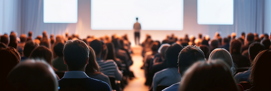 A large audience watching a leader give a presentation - Credence Communications and Coaching